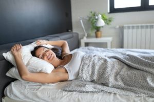 Young beautiful woman sleeping and smiles in her sleep in bed