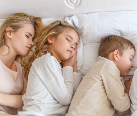 top view of mother sleeping in bed with kids