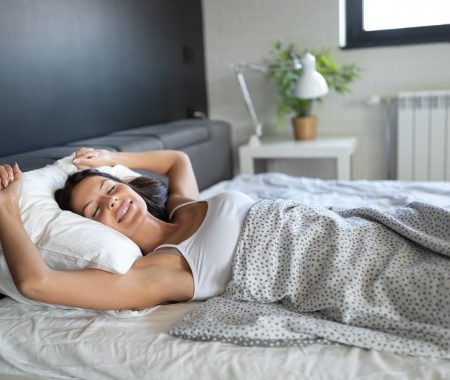 Young beautiful woman sleeping and smiles in her sleep in bed